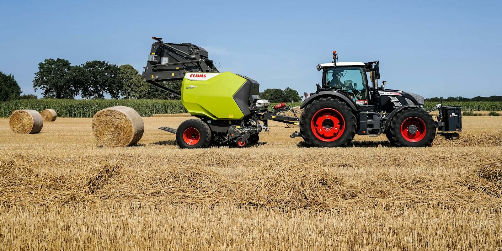 Trator com enfardadeira produzindo fardos redondos