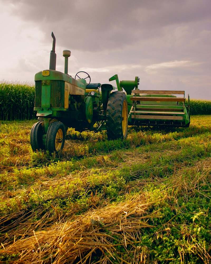 Trator agrícola com implemento acoplado em lavoura de milho