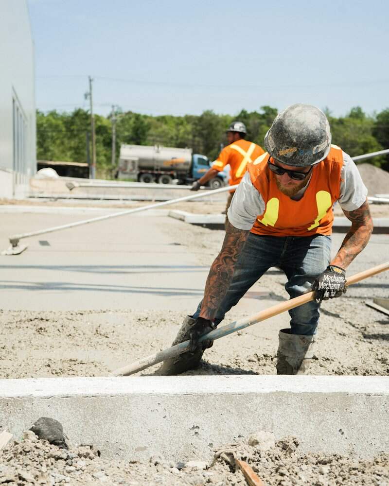 Operário acabando um contrapiso de concreto em obra